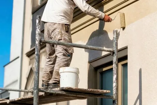 Painting a cornice from scaffolding in Boylan Heights